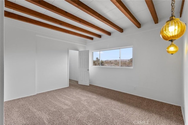 carpeted empty room with beamed ceiling