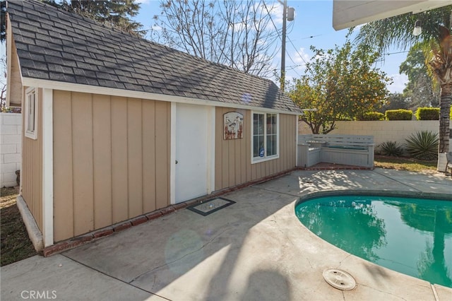 view of pool with an outbuilding and a patio