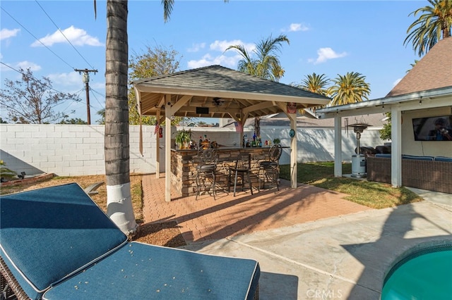 view of patio / terrace with a pool, a gazebo, an outdoor hangout area, and a bar