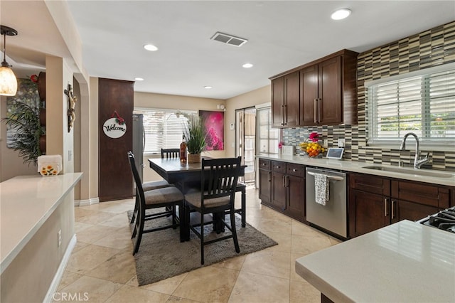 kitchen featuring sink, tasteful backsplash, dark brown cabinets, hanging light fixtures, and dishwasher