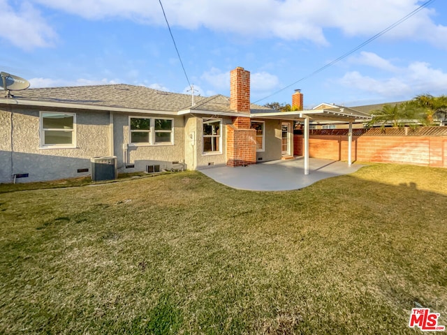 rear view of house featuring central AC unit, a patio area, and a lawn