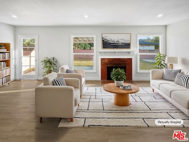 living room featuring a brick fireplace and light wood-type flooring