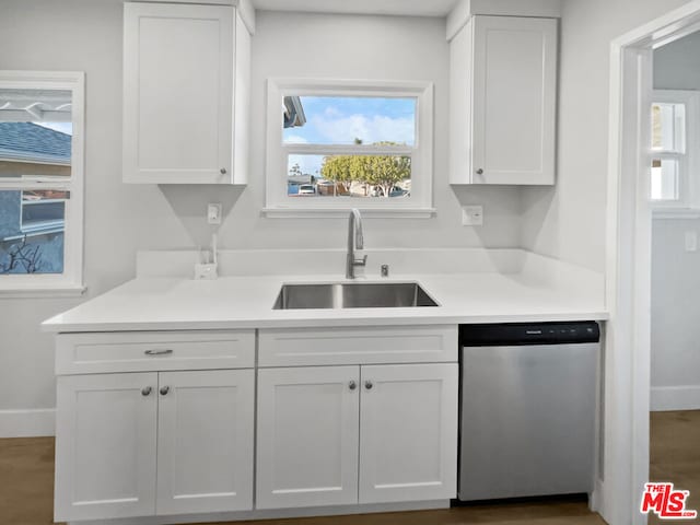 kitchen with stainless steel dishwasher, dark hardwood / wood-style floors, sink, and white cabinets