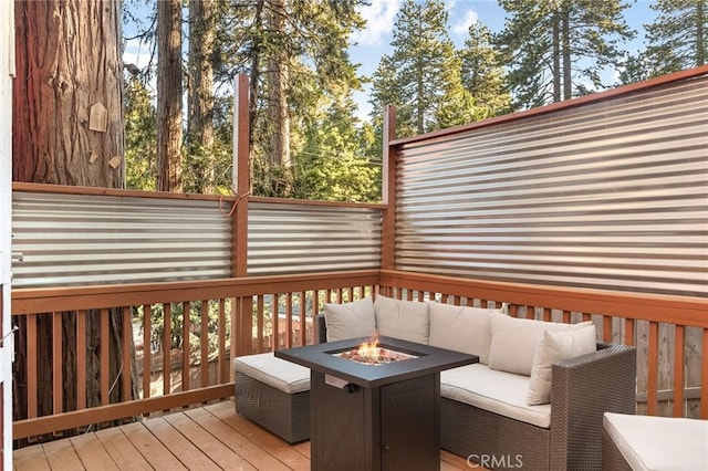 wooden terrace with an outdoor living space with a fire pit