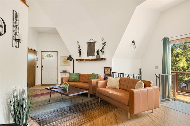 living room with high vaulted ceiling and light hardwood / wood-style floors