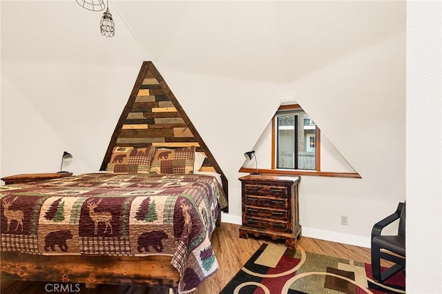 bedroom featuring vaulted ceiling and hardwood / wood-style floors