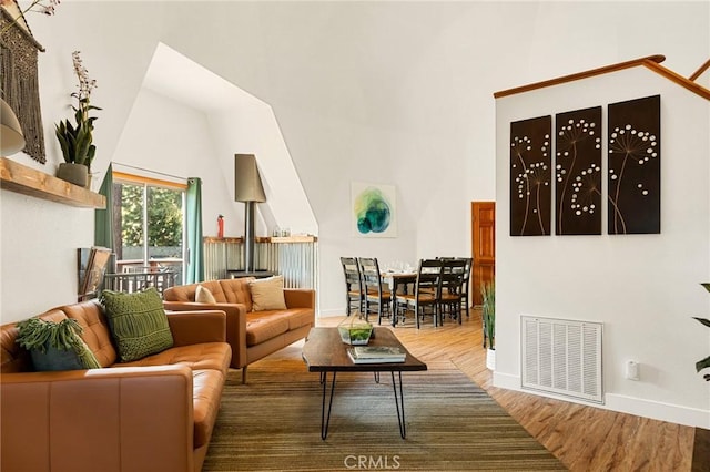 living room featuring a high ceiling and wood-type flooring