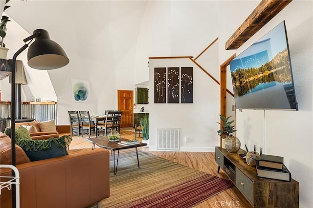 living room with hardwood / wood-style floors and a towering ceiling