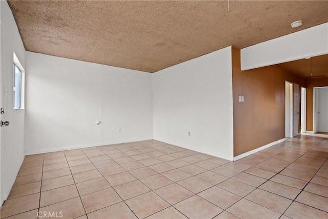 tiled spare room with a textured ceiling