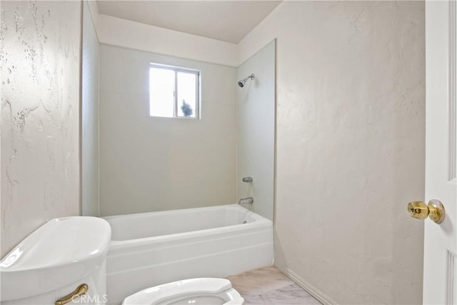 bathroom featuring tiled shower / bath combo and toilet