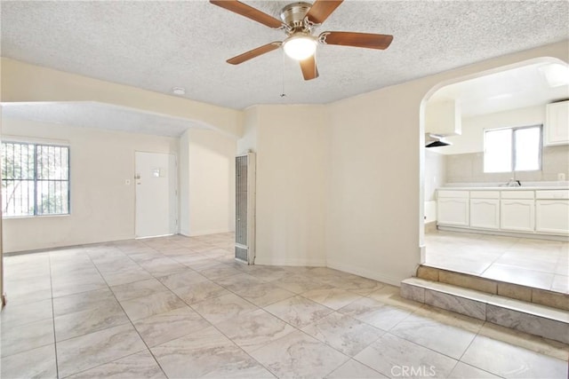 empty room featuring ceiling fan and a textured ceiling