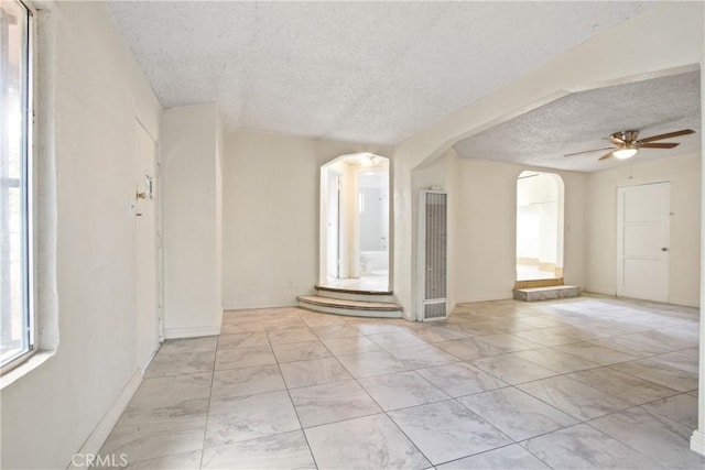 unfurnished room featuring ceiling fan and a textured ceiling