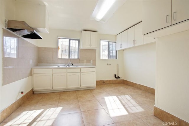 kitchen with white cabinetry, sink, and light tile patterned floors