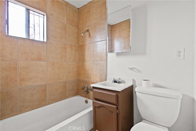 full bathroom with tiled shower / bath, vanity, and toilet