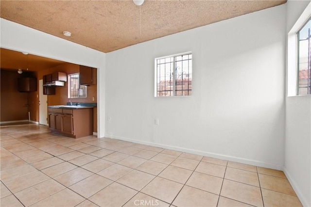 tiled spare room featuring a textured ceiling