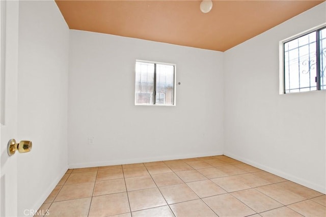 tiled spare room featuring a wealth of natural light