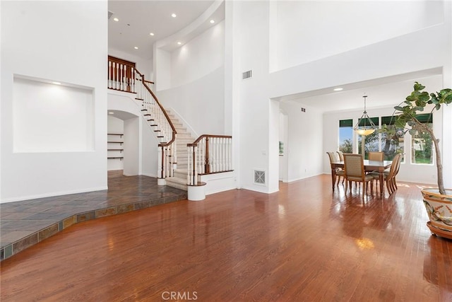 interior space featuring hardwood / wood-style flooring and a towering ceiling