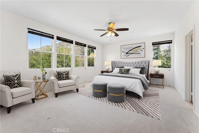 carpeted bedroom featuring multiple windows and ceiling fan