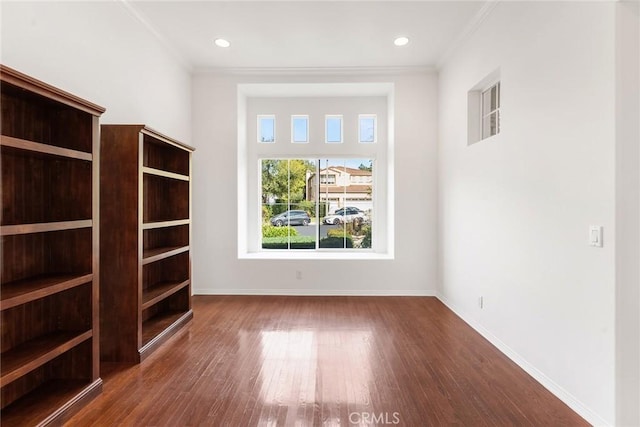 spare room with dark wood-type flooring and crown molding