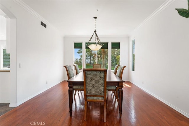 dining room with dark wood-type flooring and ornamental molding