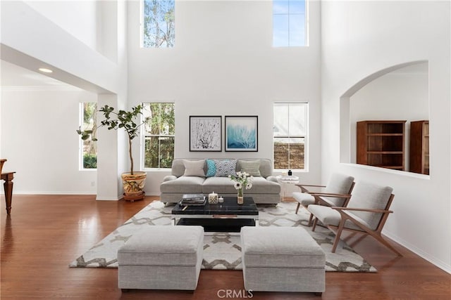 living room featuring crown molding, a wealth of natural light, and dark wood-type flooring