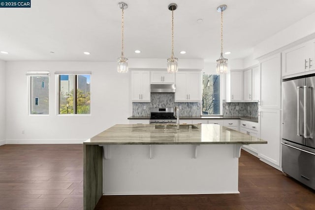 kitchen with white cabinetry, sink, stainless steel appliances, and dark stone counters