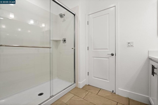 bathroom with vanity, an enclosed shower, and tile patterned flooring