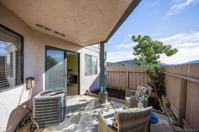 view of patio with a mountain view and central air condition unit