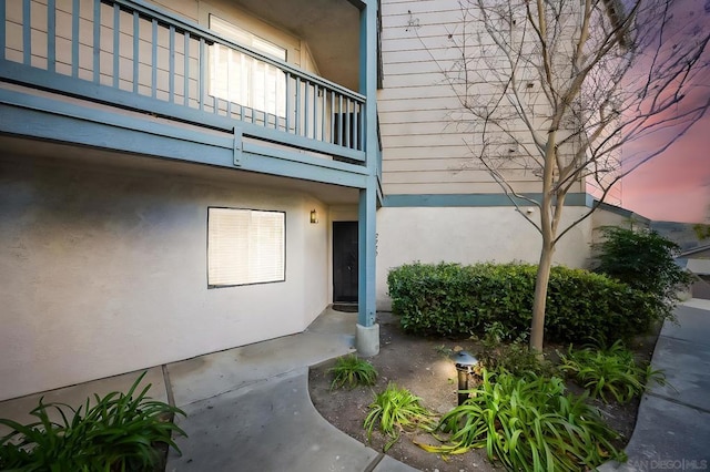 view of exterior entry featuring a balcony