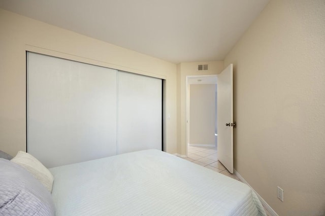 bedroom with light tile patterned floors and a closet