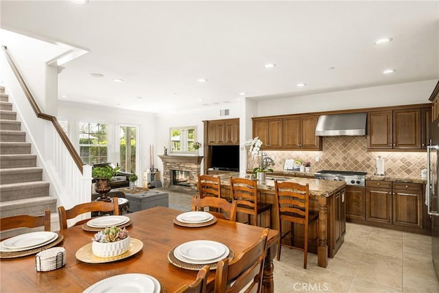 dining room with visible vents, stairway, crown molding, a fireplace, and recessed lighting