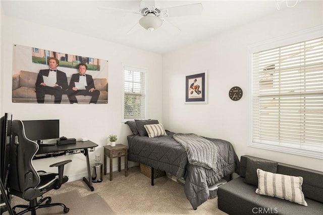 carpeted bedroom with ceiling fan and baseboards