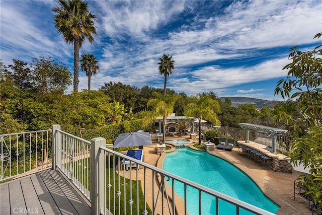 view of pool featuring a pool with connected hot tub, an outdoor stone fireplace, a patio, and a pergola