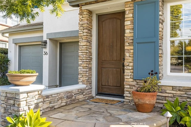 entrance to property with stone siding and stucco siding