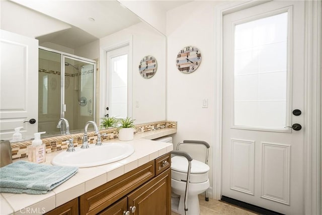 full bath with vanity, backsplash, a shower stall, and toilet