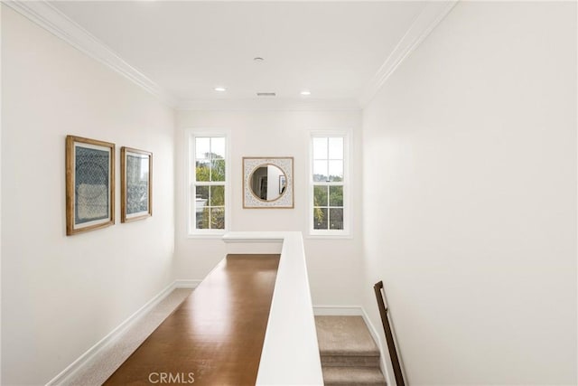 corridor featuring ornamental molding, carpet, an upstairs landing, and baseboards