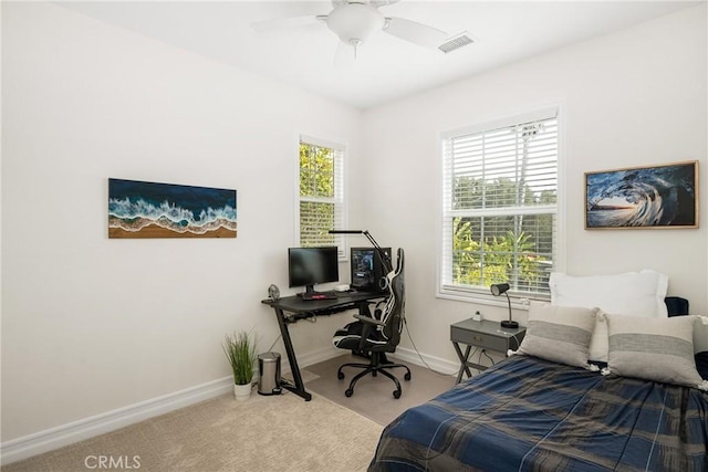 carpeted bedroom featuring a ceiling fan, visible vents, and baseboards