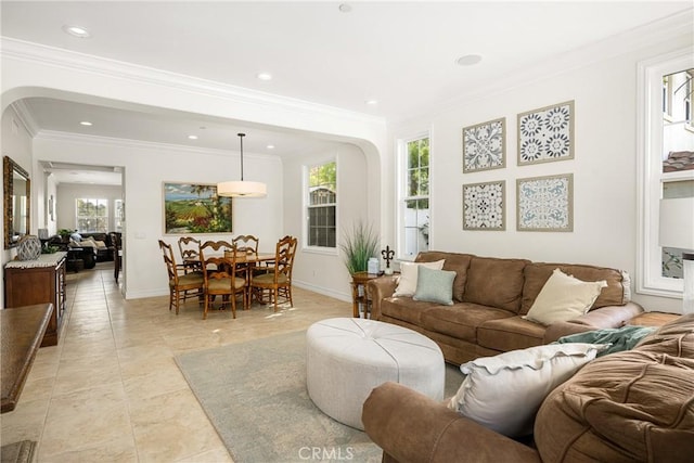 living room featuring arched walkways, crown molding, recessed lighting, and baseboards