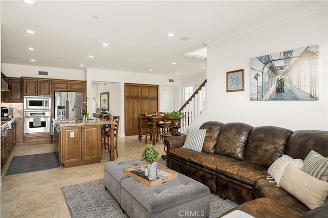 living area with ornamental molding, stairway, visible vents, and recessed lighting