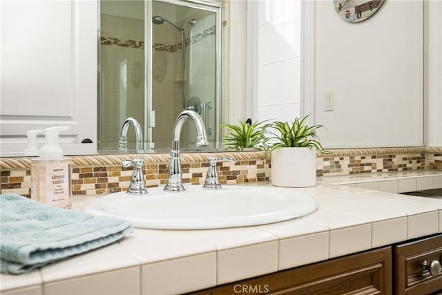 bathroom with a tile shower, backsplash, and vanity