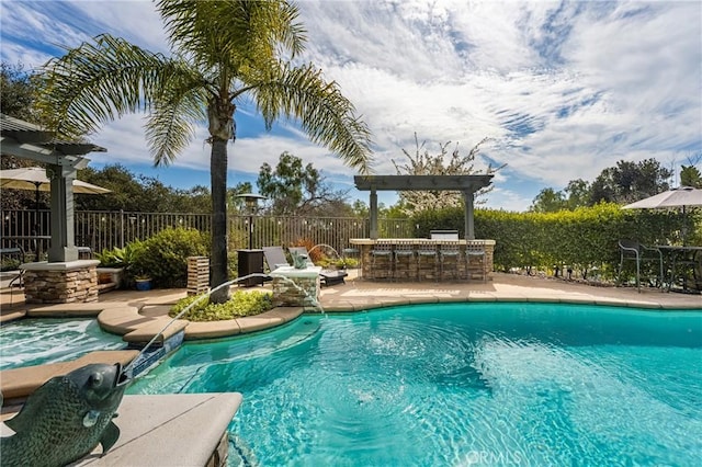 view of swimming pool with outdoor dry bar, a patio area, fence, and a pool with connected hot tub