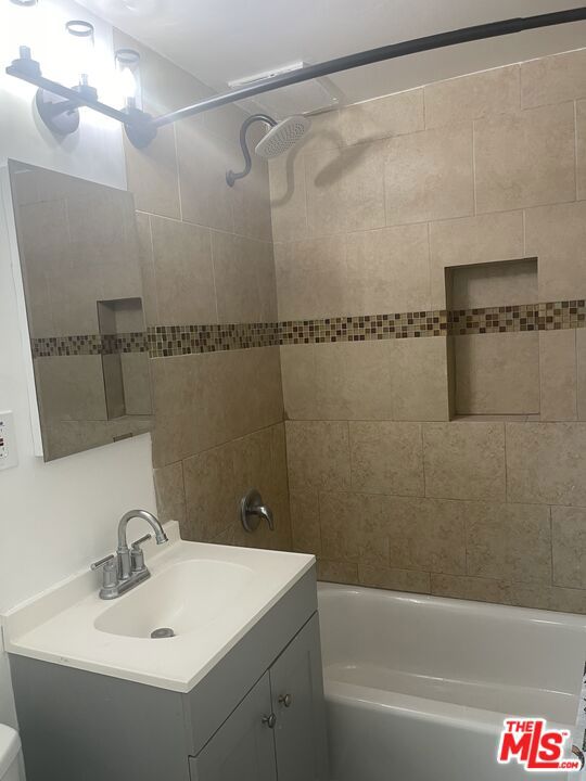 full bathroom with vanity, toilet, and tiled shower / bath