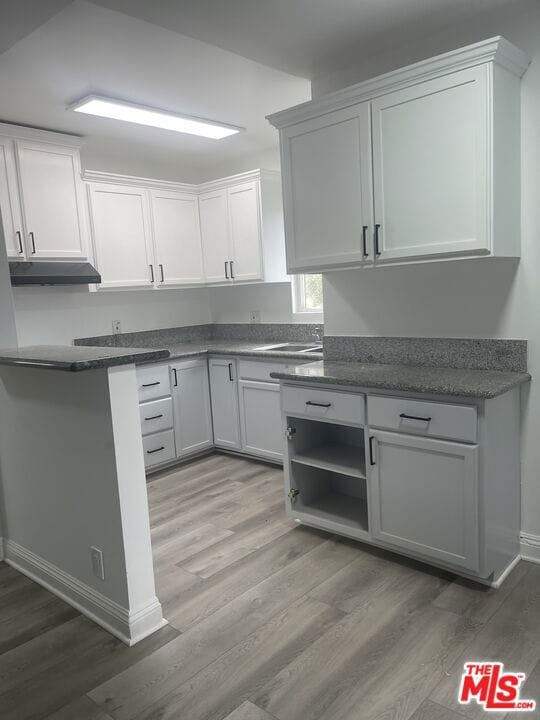 kitchen with sink, light hardwood / wood-style floors, and white cabinets