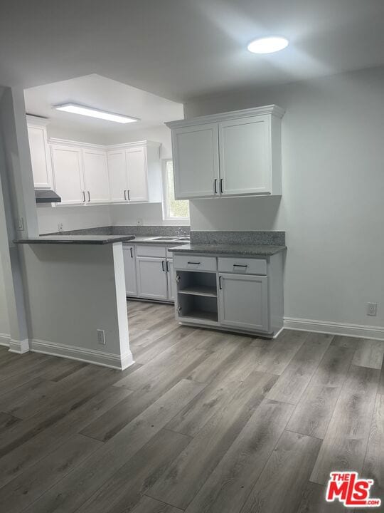 kitchen with dark hardwood / wood-style floors, sink, and white cabinets