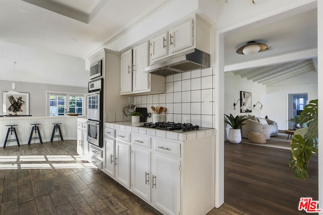 kitchen with white cabinetry, backsplash, pendant lighting, and dark wood-type flooring