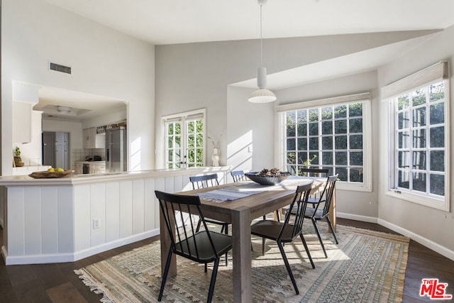 dining space featuring dark hardwood / wood-style flooring and vaulted ceiling