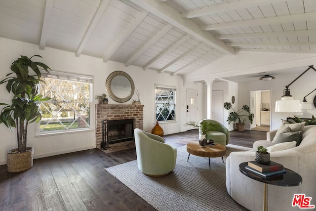 living room featuring dark hardwood / wood-style flooring, a fireplace, lofted ceiling with beams, and decorative columns