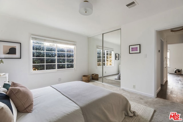 bedroom featuring light colored carpet and a closet