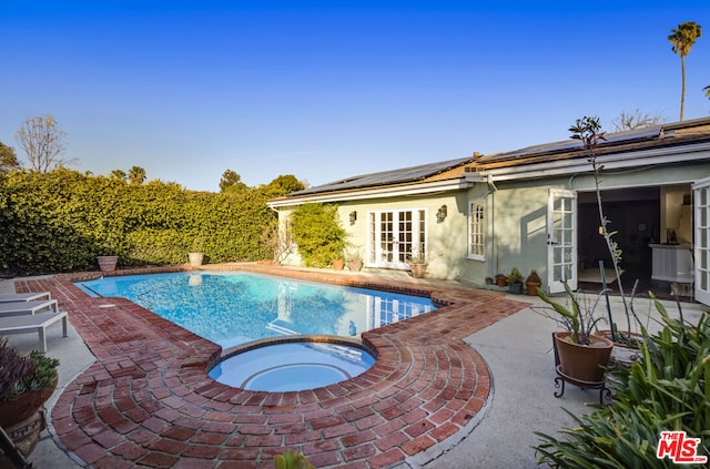 view of pool featuring french doors, an in ground hot tub, and a patio area