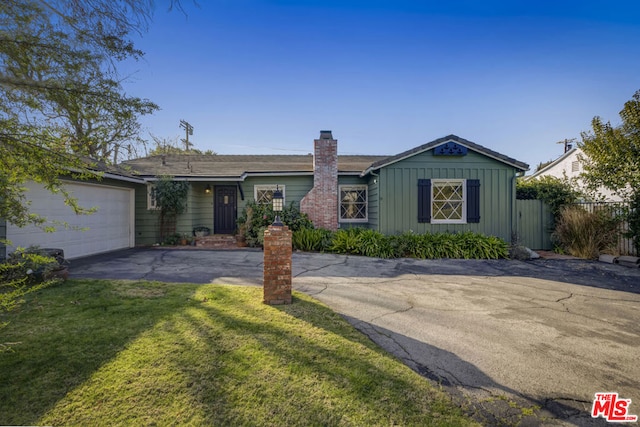 single story home featuring a garage and a front yard